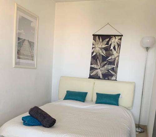 ein Schlafzimmer mit einem Bett mit zwei blauen Kissen in der Unterkunft Grand Studio proche mer avec piscine. in Antibes