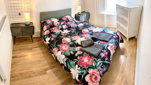 a bedroom with a bed with a floral couch at Princes House, Park Way in Liverpool