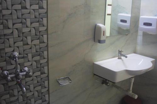 a bathroom with a sink and a toilet and a mirror at Hotel Gujrat in Nagpur