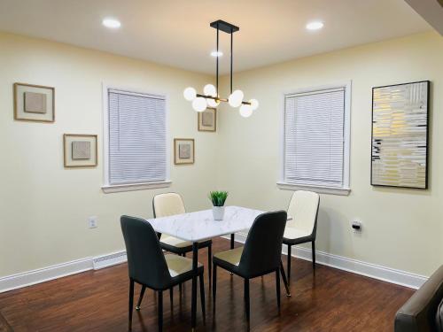 a dining room with a white table and chairs at Newly renovated charming home with parking in Fort Washington