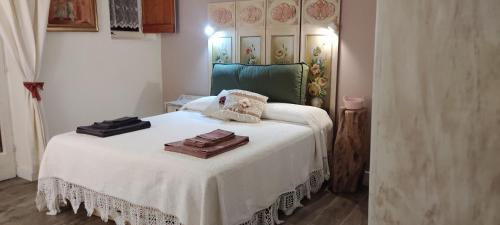 Un dormitorio con una cama blanca con toallas. en Alloggio Turistico Dakota, en Manziana