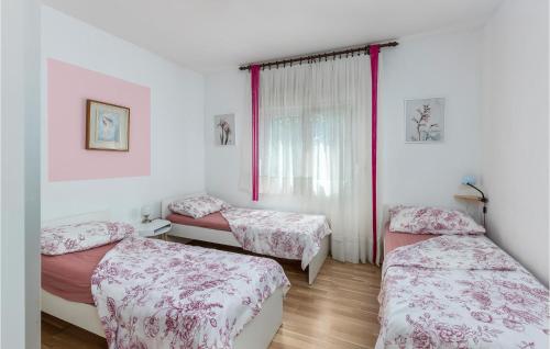 a bedroom with two beds and a window at 3 Bedroom Stunning Home In Kastav in Kastav