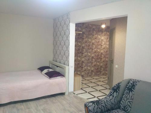 1 dormitorio con 1 cama y puerta al baño en Подобово квартира в центрі міста, en Konotop