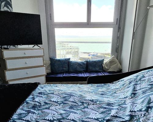 een slaapkamer met een bed en een raam bij La Pause Marine in Le Havre