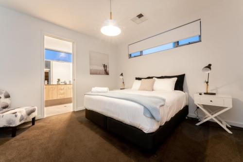a bedroom with a bed and a desk and a window at Ocean At Seaford- Beachfront Luxury-Free Wifi in Seaford