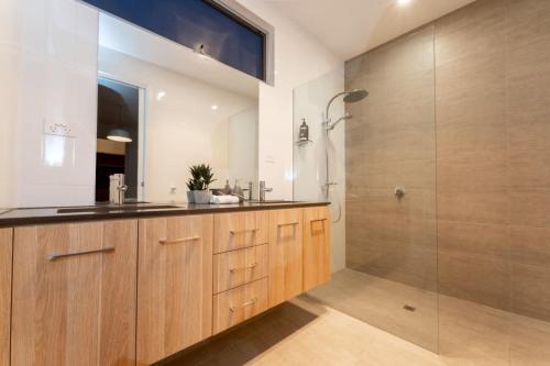 a bathroom with a sink and a shower at Ocean At Seaford- Beachfront Luxury-Free Wifi in Seaford