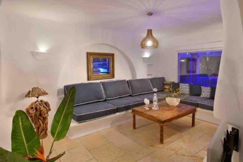 a living room with a blue couch and a table at Paraga Scorpios area Villa2 by CalypsoSunsetVillas in Paradise Beach
