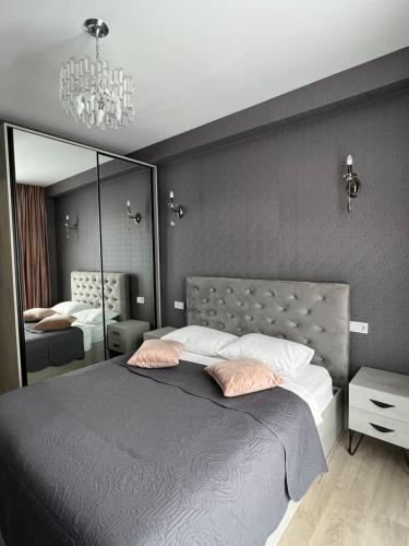 a bedroom with a large bed and a mirror at AURA in Kutaisi