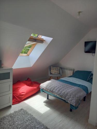una camera mansardata con letto e finestra di Maison tout confort au calme à 300m de la mer et du GR34 avec jardin a Loctudy