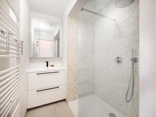 a white bathroom with a shower and a sink at Zilverzand 202 new construction located on the beach in Koksijde
