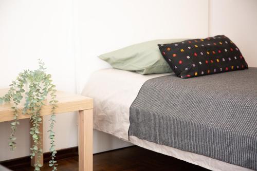 a bedroom with a bed and a table with a pillow at Cozy Room in Cascais City with Full Kitchen 5 minutes from the beach in Cascais