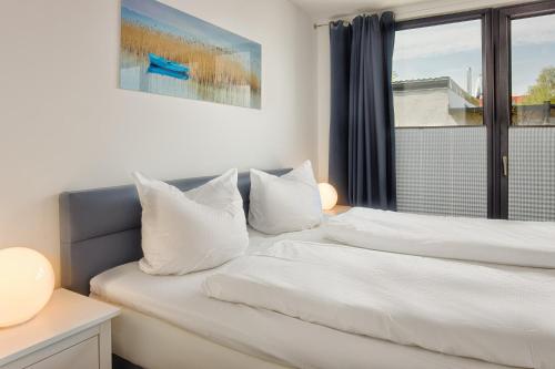 ハイリゲンハーフェンにあるJakobskojeの窓付きの客室で、ベッド2台(白い枕付)