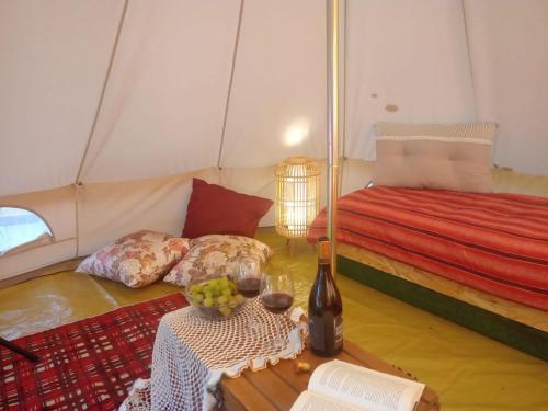 Una habitación con una cama y una mesa en una tienda de campaña en Yurta con uso piscina e vista meravigliosa, en Dicomano