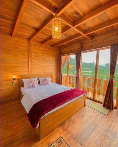 Un dormitorio con una cama y una ventana grande. en CALLA HOMESTAY DIENG, en Diyeng