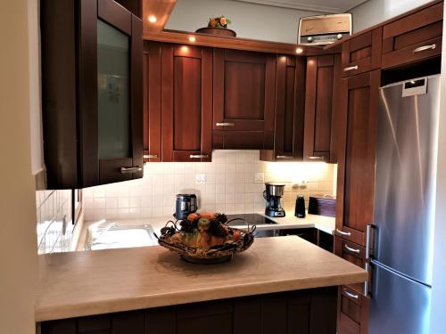 a kitchen with wooden cabinets and a bowl on a counter at ZENIA Pelion garden house in Platanidia