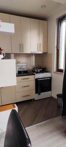 a kitchen with white cabinets and a stove top oven at Квартира в Батуми 