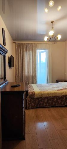 1 dormitorio con cama, escritorio y ventana en Квартира в Батуми, 