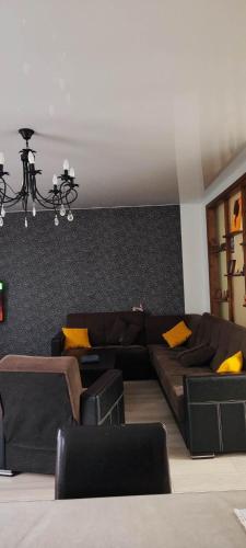 una sala de estar con sofás marrones y almohadas amarillas en Квартира в Батуми 