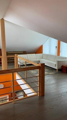 un soggiorno con divano e una scala di Bella Vita brīvdienu māja a Sigulda