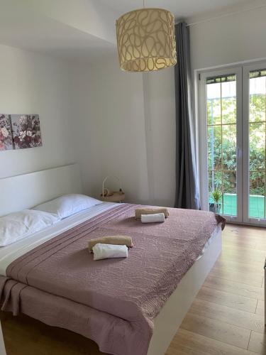 a bedroom with a large bed with two towels on it at Apartman Diana in Mali Lošinj