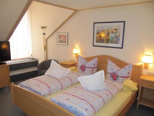 Landgasthof-Hotel Zum Anleitner في Rattenberg: غرفة نوم بسرير كبير عليها مخدات
