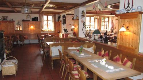Landgasthof-Hotel Zum Anleitner في Rattenberg: مطعم بطاولات وكراسي خشبية في الغرفة