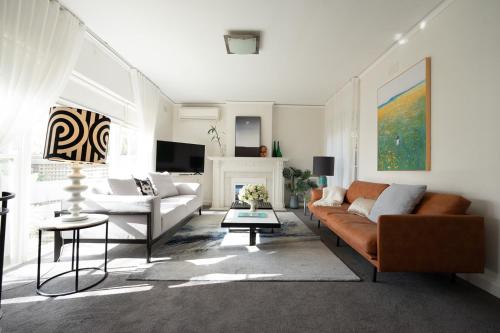 a living room with a couch and a fireplace at ToorakwhiteHouse3GrandKingBedrooms1BigGarden in Melbourne