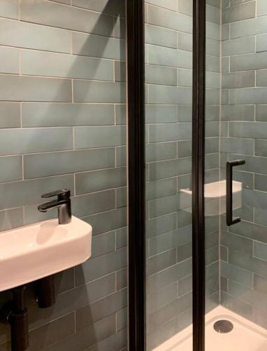 W łazience znajduje się umywalka i przeszklony prysznic. w obiekcie Country Apartment w mieście Hurstpierpoint