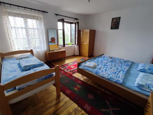 a bedroom with two beds and a rug at Leppo Guest House in Gacko