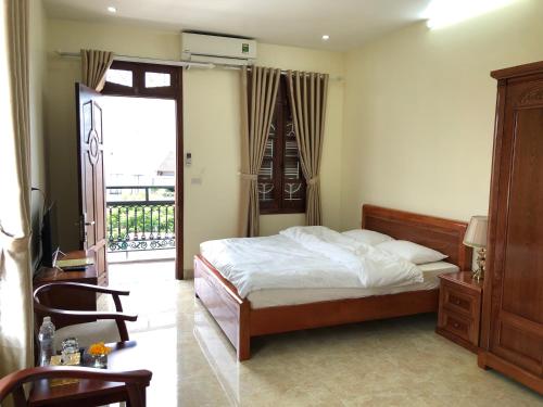 a bedroom with a bed and a door to a balcony at Maya Homestay in Hue