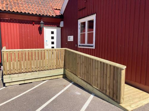 a wooden deck on the side of a red building at Morlanda B&B in Ellös