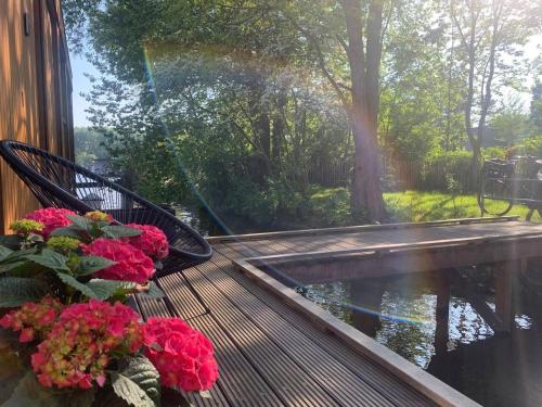 a porch with a bench and flowers and a pond at Beautiful Amstel houseboat in Amsterdam