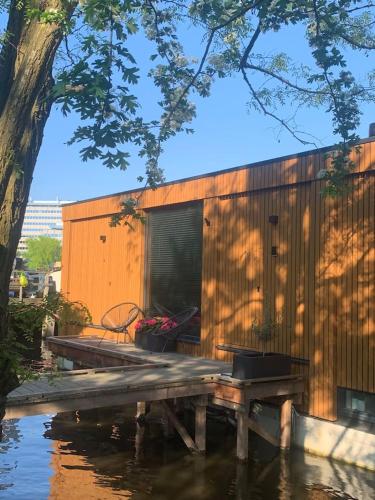a building with a table and a bench in the water at Beautiful Amstel houseboat in Amsterdam