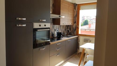 una cocina con electrodomésticos de acero inoxidable y una ventana en Casalmare Via Asse, en Ventimiglia