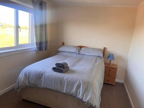 a bedroom with a bed and a window at Taigh 24, Barvas in Barvas
