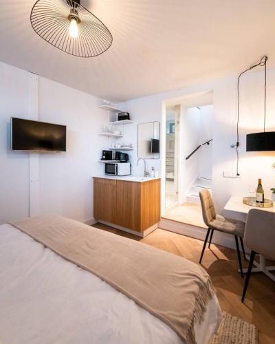 a bedroom with a bed and a kitchen with a table at Beautiful Amstel houseboat in Amsterdam