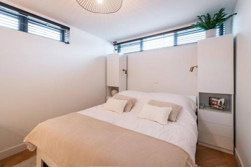 a bedroom with white walls and a bed with two pillows at Beautiful Amstel houseboat in Amsterdam