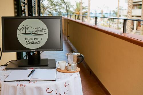 un monitor de ordenador sentado en una mesa con un Sidx Sidx de mesa en Discover Tortoreto en Tortoreto Lido
