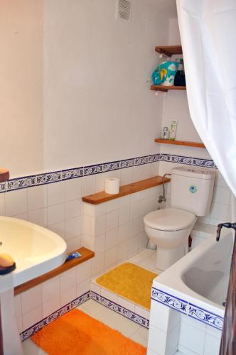 a bathroom with a toilet and a tub and a sink at Casa Muryo in Jimena de la Frontera