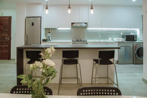 a kitchen with a counter with three bar stools at Cozy Room in Cascais City with Full Kitchen 5 minutes from the beach in Cascais