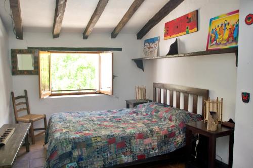 a bedroom with a bed and a table and a window at Casa Muryo in Jimena de la Frontera