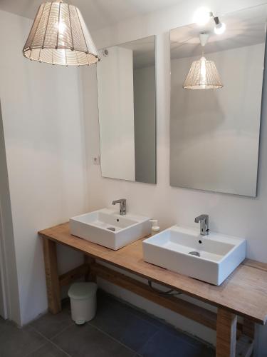 une salle de bain avec deux lavabos et un miroir dans l'établissement La Ferme du domaine de La Mazure, à La Chapelle-Basse-Mer