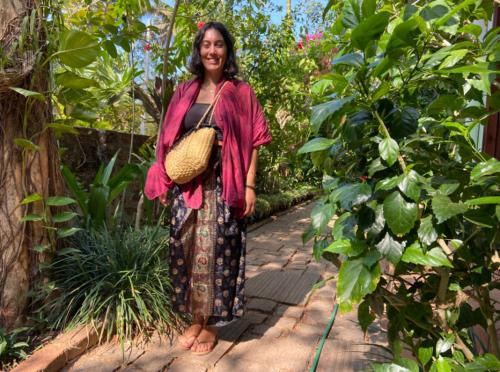 a woman standing on a path in a garden at Villa Jacaranda in Varkala