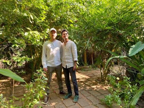 two men standing next to each other in a garden at Villa Jacaranda in Varkala