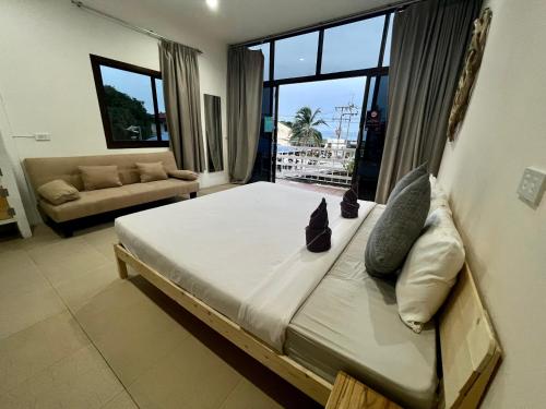 duże łóżko w pokoju z dużym oknem w obiekcie LEO HOSTEL w mieście Baan Tai