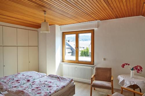 1 dormitorio con cama, ventana y mesa en Ferienwohnung Mendgen mit Panoramablick, en Bernkastel-Kues