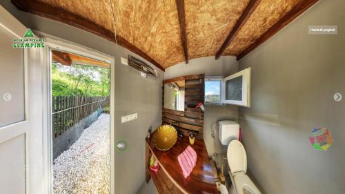 a bathroom with a toilet in a tiny house at Bosnian Pyramid Glamping in Visoko