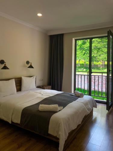 1 dormitorio con cama grande y ventana grande en Hotel Gold Kazbegi en Kazbegi