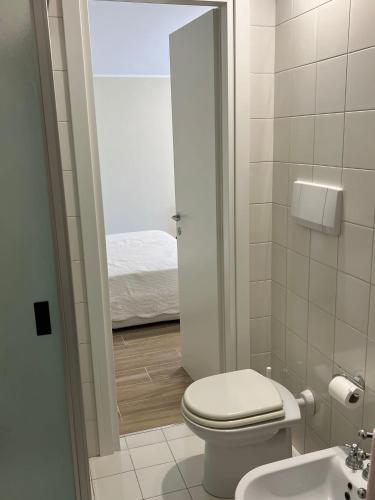 uma casa de banho com um WC, um lavatório e uma cama em Villa Rosa Augusta em Camerano