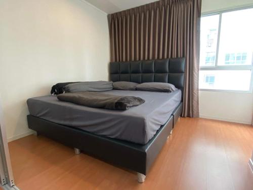 a bed with a black headboard in a bedroom at Condo in front MRT Bang Krasor, Nonthaburi, Free Wi-Fi in Nonthaburi